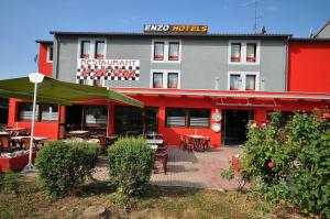 un restaurant avec des tables et des chaises en face d'un bâtiment dans l'établissement Enzo Hotels Pont-a-Mousson by Kyriad Direct, à Pont-à-Mousson