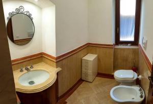 a bathroom with a sink and a toilet and a mirror at Appartamento Villa Matone in Grottaferrata