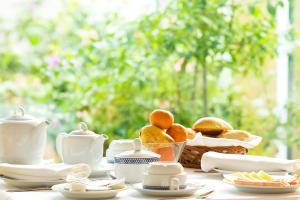 a table with a basket of bread and tea pots at Costa Nova Hotel in Costa Nova