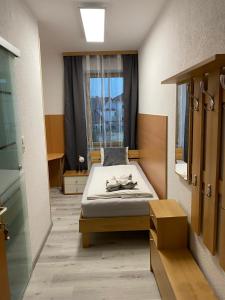 1 dormitorio con cama y ventana en Gasthaus & Hotel Backhendlstation, en Enns