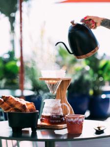 - une table avec une cafetière et du pain dans l'établissement Three House Hotel, à Funchal