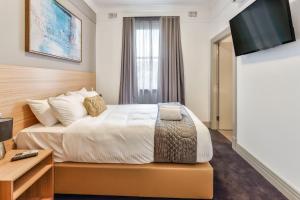 A bed or beds in a room at Meridian Hotel Hurstville