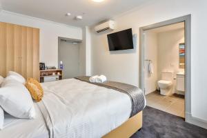 A bed or beds in a room at Meridian Hotel Hurstville