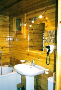 ein Badezimmer mit einem Waschbecken und einer Holzwand in der Unterkunft Chalet cosy a Sixt Fer a Cheval avec vue sur la montagne in Sixt