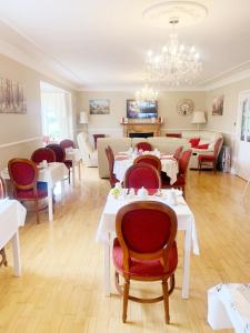 uma sala de jantar com mesas e cadeiras e um lustre em Rockfield Manor B&B, Knock em Knock