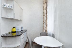 a small white kitchen with a table and chairs at Апартаменти в Старому Місті Sweet House in Kamianets-Podilskyi