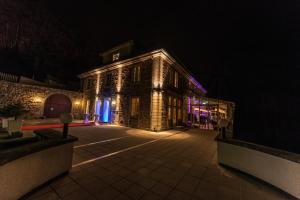 un gran edificio con luces encendidas por la noche en Berghotel Eisenach, en Eisenach