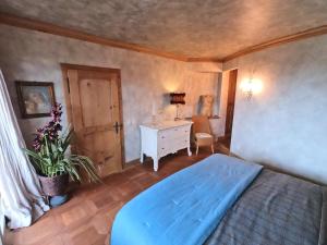 a bedroom with a blue bed and a desk at Beautiful apartment over the mountain in Crans-Montana