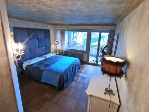 a bedroom with a blue bed and a window at Beautiful apartment over the mountain in Crans-Montana