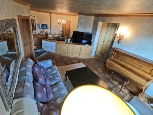 a living room with a couch and a television at Beautiful apartment over the mountain in Crans-Montana