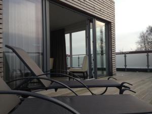 - un balcon avec des chaises et des portes en verre dans un bâtiment dans l'établissement Hotel Insel Pension, à Niebüll