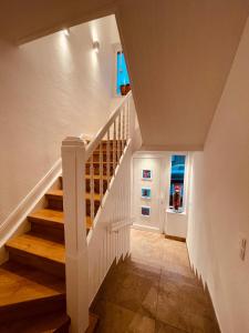 a staircase with white railings in a house at City Apartment Ochtrup - NETFLIX - WALLBOX in Ochtrup