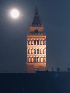 een hoog gebouw met de maan op de achtergrond bij Appartamenti Forteguerriana in Pistoia