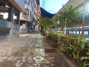 una calle vacía con un tren en la distancia en Hostal Pablo's House, en Machu Picchu