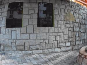 Una pared de piedra con tres ventanas. en Hostal Pablo's House, en Machu Picchu