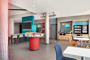 a restaurant with tables and chairs and a counter at avid hotels - Prattville - Montgomery North, an IHG Hotel in Prattville