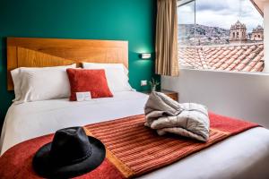 Cette chambre d'hôtel comprend un lit avec un chapeau. dans l'établissement Maytaq Wasin Boutique Hotel, à Cusco