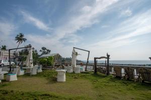 um casamento na praia com cadeiras e guarda-sóis e o oceano em State Beach Resort And Spa em Kannur