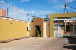 un edificio giallo con un cancello sul lato di Departamentos Tequila a Tequila