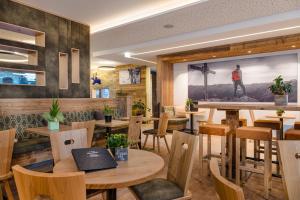 um restaurante com mesas e cadeiras de madeira e um quadro na parede em AlpenParks Hotel & Apartment Hochkönig em Mühlbach am Hochkönig