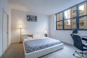 - une chambre avec un lit, un bureau et des fenêtres dans l'établissement Heaven On Baltimore at Harborfront, à Baltimore