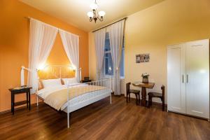 um quarto com uma cama, uma mesa e cadeiras em Post House Rooms em Lviv