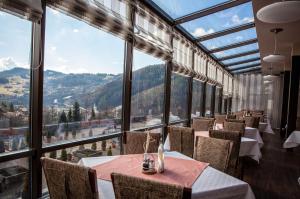 ein Restaurant mit Tischen und Stühlen und großen Fenstern in der Unterkunft Hotel SPA Budowlani in Szczawnica