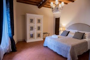 een slaapkamer met een bed en een kroonluchter bij Appartamento I Bacchettoni in Pistoia