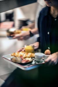 una persona sosteniendo una bandeja con un plato de comida en YUST Antwerp, en Amberes