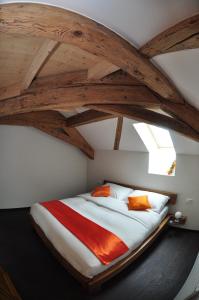 Cama grande en habitación con techo de madera en Le Relais du Château Monney, en Cournillens