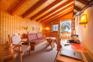 a living room with a couch and a table with a laptop at Alpenhof in Grindelwald