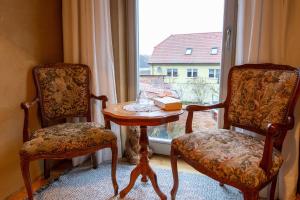 een kamer met 2 stoelen, een tafel en een raam bij Ferienwohnungen Muehlenblick in Röbel