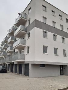 - un bâtiment blanc avec des balcons sur le côté dans l'établissement Swiss Luxury Apartment, à Mosonmagyaróvár