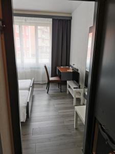 - une chambre avec un lit, un bureau et une table dans l'établissement Hotel Fleur-de-Lys, à La Chaux-de-Fonds