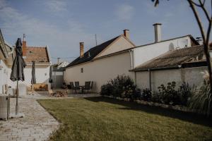 une cour avec une maison et une terrasse avec un parasol dans l'établissement Peter Lamster Top1, à Frauenkirchen