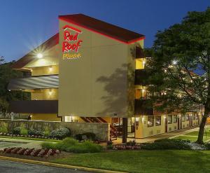 een gebouw met een dak en een bord erop bij Red Roof Inn PLUS+ Washington DC - Oxon Hill in Oxon Hill