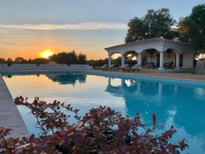 una piscina con gazebo e il tramonto di Quinta do Amauriz a Évora