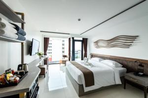 A bed or beds in a room at Blackwoods Hotel Pattaya - SHA Extra Plus