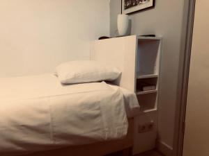 Bett mit weißer Bettwäsche und Kissen in einem Zimmer in der Unterkunft Hotel Centraal in Harlingen