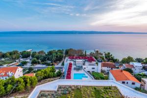 an aerial view of a house and the water at Hotel Plaža Duće in Duće