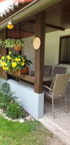 une terrasse avec une table, une chaise et des fleurs dans l'établissement Apartment Sonce, à Bohinj