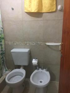 a small bathroom with a toilet and a sink at Departamento Libertad in San Salvador de Jujuy