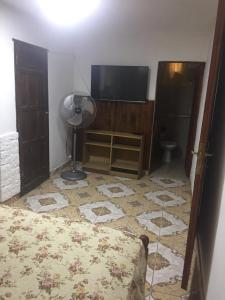 a bedroom with a tv and a bed and a floor at Departamento Libertad in San Salvador de Jujuy