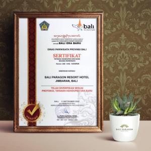 a picture of a diploma in a frame next to a plant at Bali Paragon Resort Hotel in Jimbaran