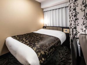 Tempat tidur dalam kamar di APA Hotel Shin Osaka Minamikata Ekimae