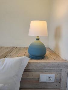 eine blaue Lampe auf einem Tisch neben einem Bett in der Unterkunft Casa do Alto in Vilamoura