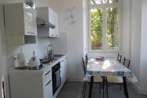 a kitchen with a table and a sink and a window at Villa Peachey, Intero piano con giardino in Stresa