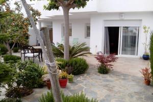 a patio with plants and a table and chairs at Bonito apartamento de 3 hab. con jardín in Roses