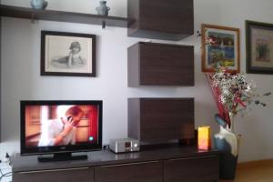 a living room with a television on a table at Bonito apartamento de 3 hab. con jardín in Roses