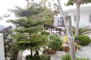 a patio with trees and a table and chairs at Bonito apartamento de 3 hab. con jardín in Roses